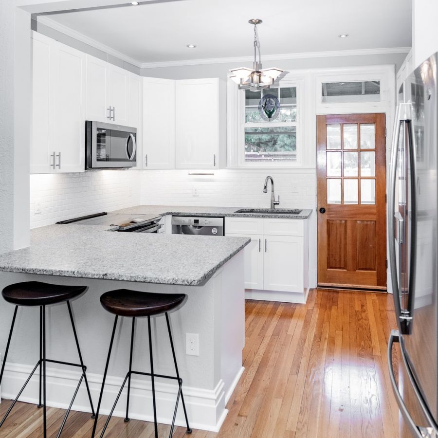 Modern White Kitchen With Wooden Floor And Bar Stools
