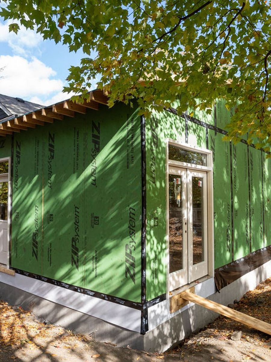 New House Construction With Green Siding And Fence